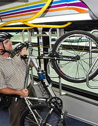 Bicyclist loading bike onto rack inside a Brio bus